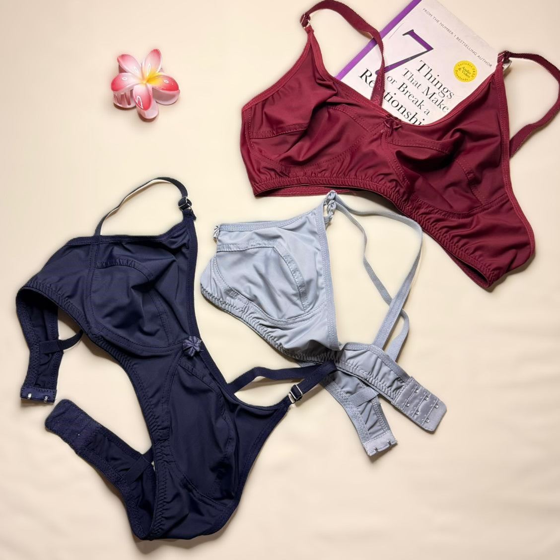 Maroon and navy bikinis with gray underwear on a beige background