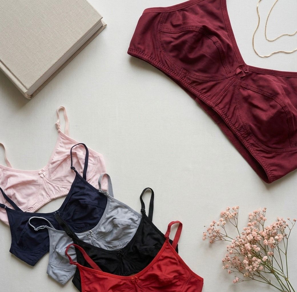 Set of women's lingerie including bras and panties on a light surface with flowers.